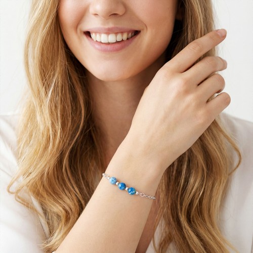 Bransoletka z niebieskim jaspisem na ręce modelki delikatna biżuteria błękitna talizman spokoju