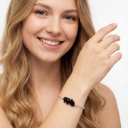 Bransoletka z czarnym turmalinem na ręce modelki delikatna biżuteria ochronna nieregularne kamienie