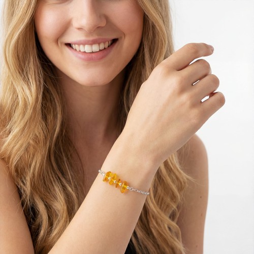 Bransoletka z bursztynem na ręce modelki delikatna biżuteria ze złota bałtyku na lato