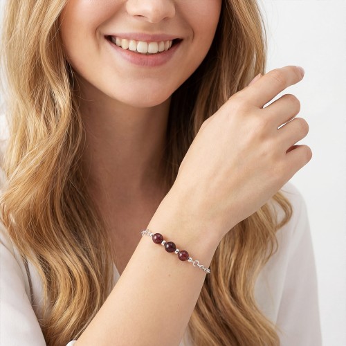 Bransoletka z granatem na ręce modelki delikatna biżuteria czerwona talizman pasji